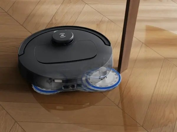Je ziet de robotstofzuiger dweilen rond een tafelpoot. Te koop bij Coolblue