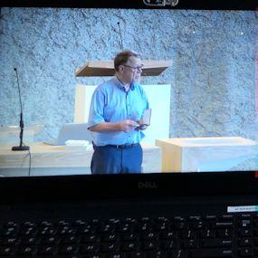 Afbeelding van laptopscherm met daarop de opname van het hoorcollege.