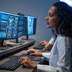 Persoon onderzoekt MRI-scans achter de computer.