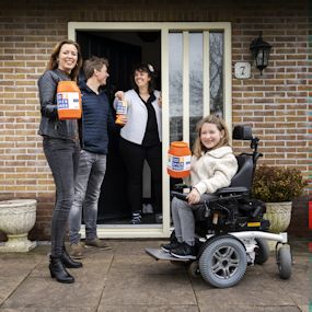 3 staande personen en 1 persoon in een rolstoel