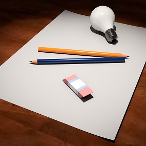 Papier met daarop potloden, gum en lamp
