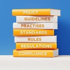 Boeken compliance, regulations, rules, standards, practices, guidelines and policy op elkaar gestapeld.